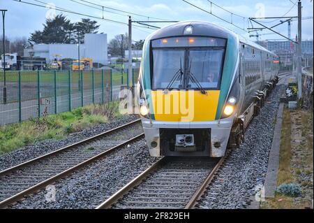 Dublino, Irlanda - 14 marzo 2021: Splendida vista serale in primo piano del treno interurbano in azione visto dalla stazione ferroviaria di Blackrock. Contesto industriale Foto Stock