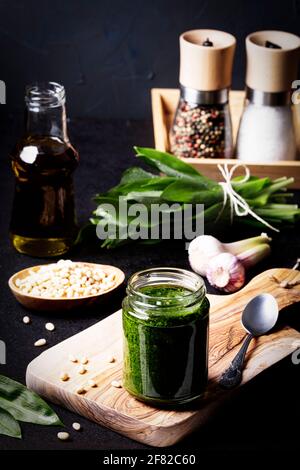 Aglio selvatico appena raccolto in un cesto di filo, impacchettato, con cesoie da giardino su tavolo di legno scuro Foto Stock