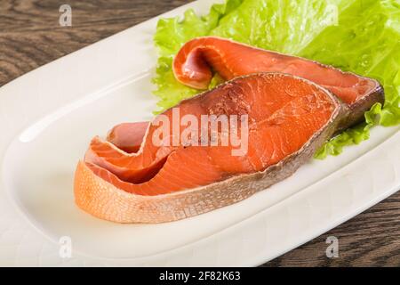 Due bistecca di pesce di salmone rosa servivano foglie di insalata Foto Stock