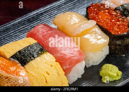 Impostazione di panini di sushi con caviale e pesce fresco tritato sullo sfondo, cibo asiatico, cibo tradizionale giapponese Foto Stock