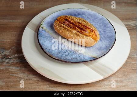 hot dog con verdure in un panino croccante con sesamo semi in una piastra Foto Stock