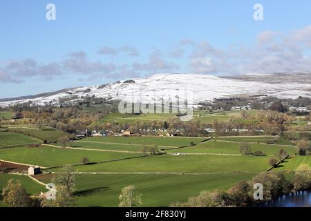 Middleton-in-Teesdale, Teesdale, County Durham, Regno Unito. 11 aprile 2021. Regno Unito Meteo. Gli acquazzoni di neve sopra Middleton-in-Teesdale lasciano una linea di demarcazione stellare fra l'inverno nelle colline e le condizioni primaverili nella valle. Credit: David Forster/Alamy Live News Foto Stock