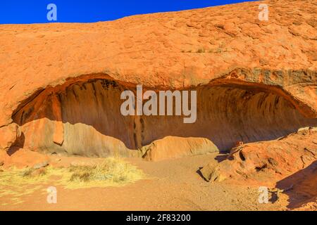 Formazione rocciosa a forma d'onda o Kitchen Cave lungo Mala Walk alla base di Ayers Rock nel Parco Nazionale Uluru-Kata Tjuta nel territorio del Nord, Australia Foto Stock