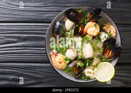 Zuppa di molluschi di pesce di cozze, gamberi, vongole e altri frutti di mare tipico piatto cileno Paila marina o Mariscal primo piano in una ciotola sul tavolo. H Foto Stock