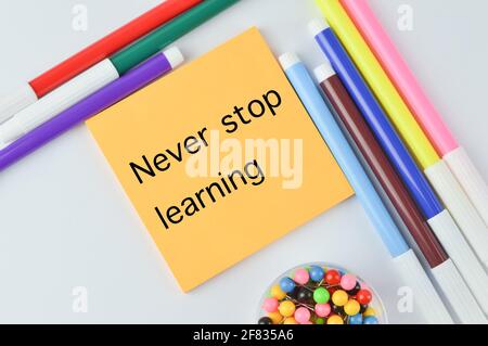 Colori colorati delle penne e note scritte con NEVER STOP APPRENDIMENTO Foto Stock