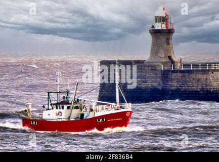 La piccola nave entra nel fiume Tyne in acqua discontinua Foto Stock