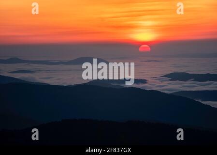 Il sole che sorge su un mare di nebbia preso dal Parco Nazionale di Shenandoah in Virginia in una mattina di inizio giugno. Foto Stock