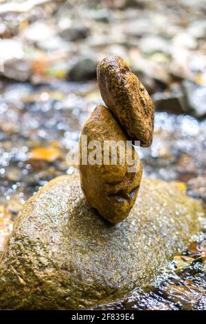 Rocce accatastate accanto al torrente nella foresta Foto Stock