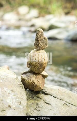 Rocce accatastate accanto al torrente nella foresta Foto Stock