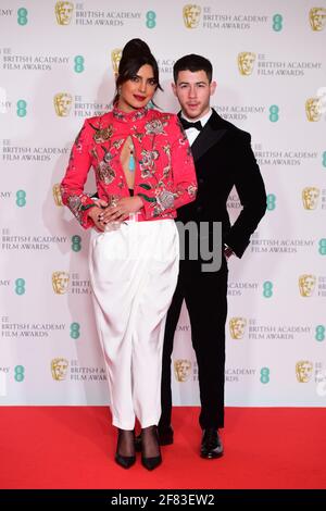 Priyanka Chopra Jonas e suo marito Nick Jonas arrivano per l'EE BAFTA Film Awards alla Royal Albert Hall di Londra. Data immagine: Domenica 11 aprile 2021. Foto Stock