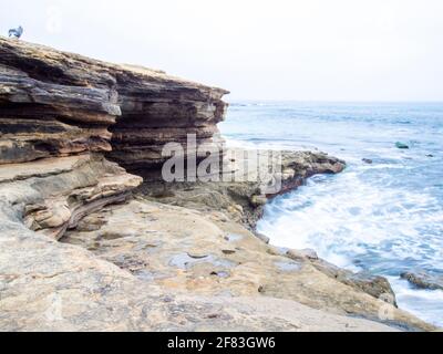 oceano costa con onde e rocce in una giornata di moody Foto Stock