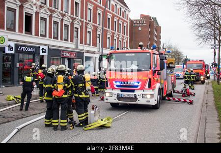 Amburgo, Germania. 11 Apr 2021. I vigili del fuoco si trovano di fronte a un appartamento in fiamme nel quartiere di Billstedt. Molte persone sono rimaste ferite nel fuoco questo pomeriggio. Credit: Daniel Bockwoldt/dpa/Alamy Live News Foto Stock