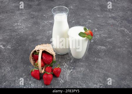 Yogurt sano biologico bevibile Kefir in un bicchiere. Primo piano su un bicchiere pieno di Kefir bianco arricchito con alcune foglie di menta. Foto Stock