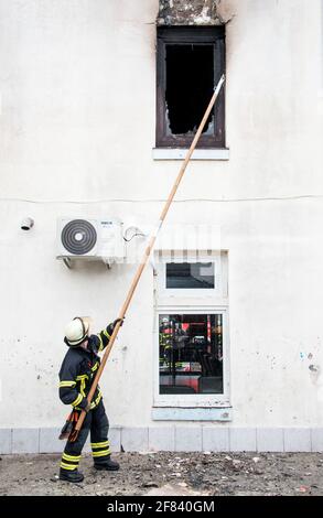 Amburgo, Germania. 11 Apr 2021. Un pompiere si trova di fronte a un appartamento in fiamme nel quartiere di Billstedt. Molte persone sono rimaste ferite nel fuoco questo pomeriggio. Credit: Daniel Bockwoldt/dpa/Alamy Live News Foto Stock