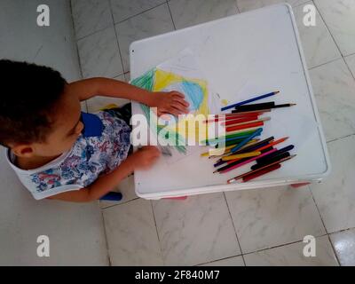 salvador, bahia / brasile - 18 novembre 2020: Il bambino si vede dipingere un disegno della bandiera del Brasile durante le attività scolastiche. Foto Stock