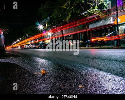 Le luci posteriori rosse si illuminano da un'auto che passa da a. notte in città Foto Stock