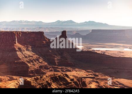 Canyon di roccia rosso brillante al mattino con le montagne la distanza Foto Stock