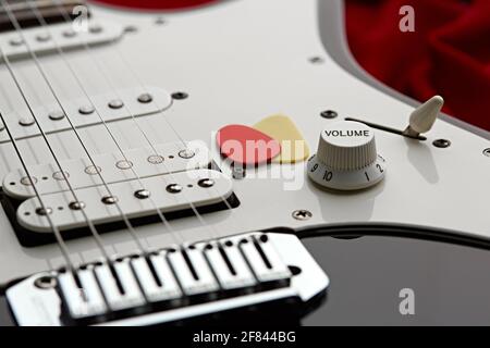 Closeup chitarra elettrica, sfondo rosso, nessuno Foto Stock