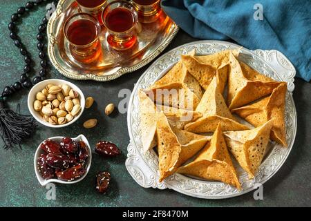 Cucina araba. Ramadan Kareem festivo. Menu Ramadan, katayef pancake arabo (katayev, qatayef) e date, pistacchio. Foto Stock