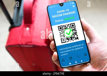 Passaporto sanitario della vaccinazione COVID-19 in telefono cellulare per viaggi, il turista tiene smartphone con app passaporto. Certificato digitale, prova di coronavi Foto Stock
