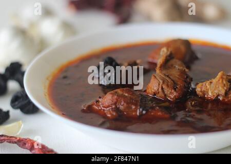 curry di pesce con sugo di carne rosso preparato in stile tradizionale kerala. Il pesce utilizzato è rosso rosso, localmente noto come vatta. Scatto su sfondo bianco Foto Stock