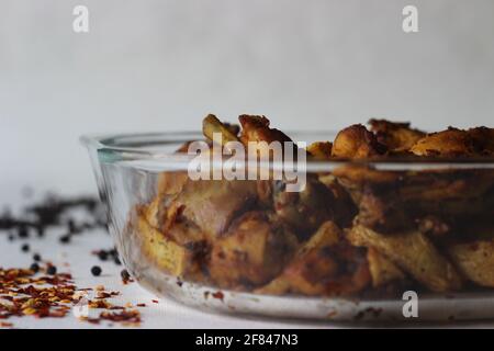 Frittura di pollo secca e spicchi di patate, fritti all'aria. Scatto su sfondo bianco Foto Stock