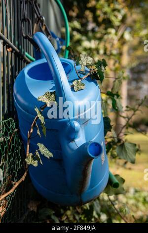 annaffiatura lattine nel loro posto di deposito ad un cimitero Foto Stock