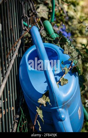 annaffiatura lattine nel loro posto di deposito ad un cimitero Foto Stock