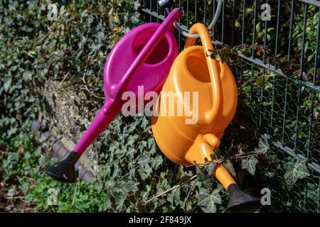 annaffiatura lattine nel loro posto di deposito ad un cimitero Foto Stock