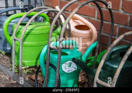 annaffiatura lattine nel loro posto di deposito ad un cimitero Foto Stock