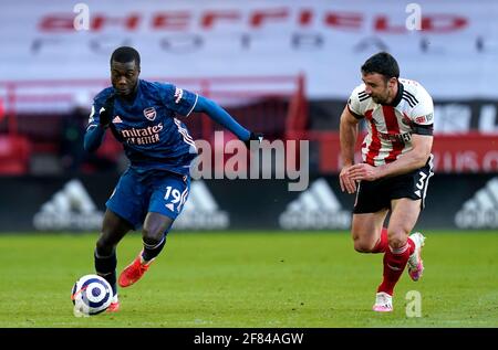 Nicolas Pepe di Arsenal (a sinistra) e Enda Stevens di Sheffield United combattono per la palla durante la partita della Premier League a Bramall Lane, Sheffield. Data immagine: Domenica 11 aprile 2021. Foto Stock