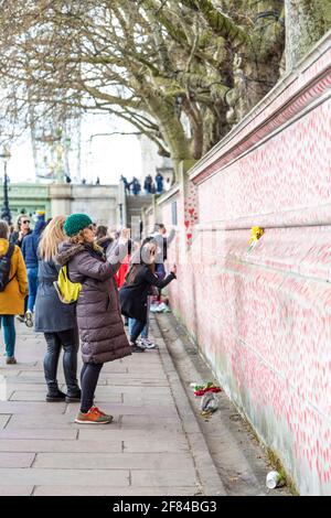 11 aprile 2021, Londra, UK - Donna che scatta le foto del National COVID Memorial Wall lungo la South Bank Foto Stock