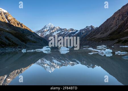 Mount Cook alla luce del mattino, all'alba, al riflesso nel lago Hooker con i galleggianti di ghiaccio, il Mount Cook National Park, le Alpi meridionali, Hooker Valley, Canterbury Foto Stock