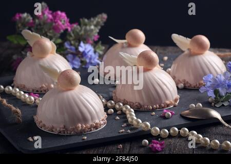 Dolci mousse alla moda con riflessi rosa. Sfondo scuro Foto Stock