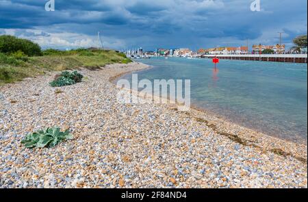 Fiume Arun in alta marea, preso su una riva di ghiaia dal lato ovest del fiume guardando giù l'estuario a Littlehampton, Sussex occidentale, Inghilterra, Regno Unito. Foto Stock