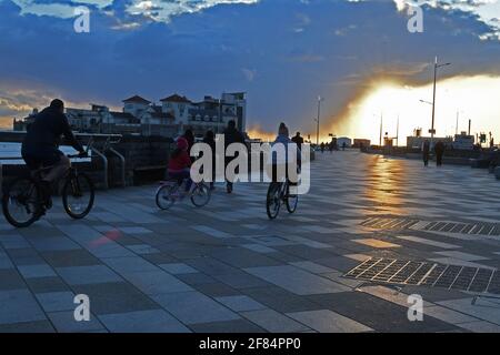 Weston Super Mare, Regno Unito. 11 Apr 2021. Su una fredda sera i ciclisti sono visti sulla passeggiata come i tramonti sopra Weston Super Mare, Somerset del Nord.Picture Credit: Robert Timoney/Alamy Live News Foto Stock