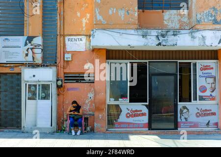 Donna che riposa su una strada decaduta nel Centro Historico Merida Messico. Il vecchio centro è stato particolarmente colpito dagli effetti economici della pandemia di Covid-19 Foto Stock