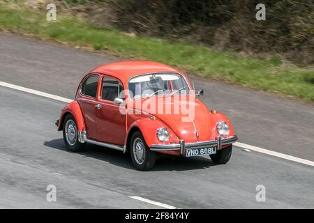 1972 anni '70, di vecchio tipo arancione VW Volkswagen Beetle; guida sulla M6 autostrada vicino Preston in Lancashire, Regno Unito. Foto Stock