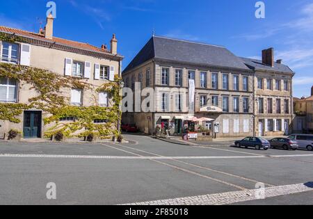 Le Dorat, Francia - 22 agosto 2019: Case, caffè e negozi in Place de la Collegiale vicino alla chiesa di Saint-Pierre-es-Liens a le Dorat Foto Stock