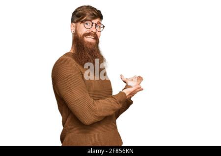 Giovane irlandese rosso uomo che indossa abiti casual e occhiali invitanti per entrare sorridente naturale con la mano aperta Foto Stock