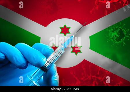 Campagna di vaccinazione del Burundi Covid-19. Una mano in un guanto di gomma blu contiene una siringa con vaccino del virus covid-19 davanti alla bandiera del Burundi. Coronavirus Foto Stock