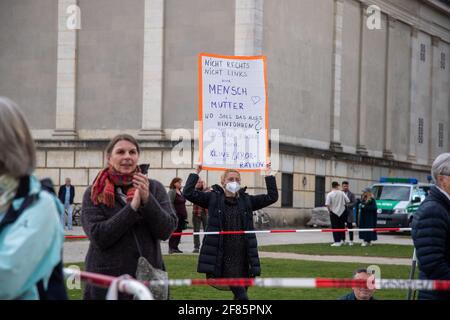 Demonstrantin hält Schild mit der Aufschrift: ' Nicht rechts nicht links/Nur Mensch und Lutter/WO soll das alles hinführen?/Unsere Kinder sind keine Laborratten '. Hunderte Menschen aus dem Querdenken Spektrum versammelten sich am 11. Aprile 2021 a München, um gegen sämtliche Corona Maßnahmen zu demonstrieren. - il 11 2021 aprile centinaia di persone hanno partecipato a una manifestazione contro tutte le misure del Covid a Monaco, in Germania. (Foto di Alexander Pohl/Sipa USA) Credit: Sipa USA/Alamy Live News Foto Stock