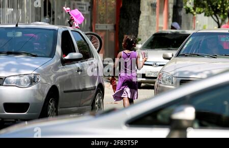 salvador, bahia / brasile - 24 dicembre 2014: Il bambino è visto chiedendo donazioni nel mezzo del traffico di veicoli nel quartiere Pituba di Salvado Foto Stock