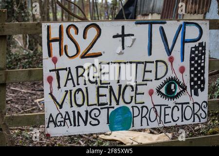 Wendover, Regno Unito. 9 aprile 2021. Un segnale che suggerisce che la polizia della HS2 e della Thames Valley usano la 'violenza mirata' contro i protettori degli alberi è raffigurato fuori dal campo di resistenza attivo di Wendover, che è occupato da attivisti contrari al collegamento ferroviario ad alta velocità HS2. Il lavoro di abbattimento degli alberi per il progetto si sta svolgendo in diverse località tra il Grande Missenden e Wendover nell'AONB Chilterns, anche di fronte al campo. Credit: Mark Kerrison/Alamy Live News Foto Stock