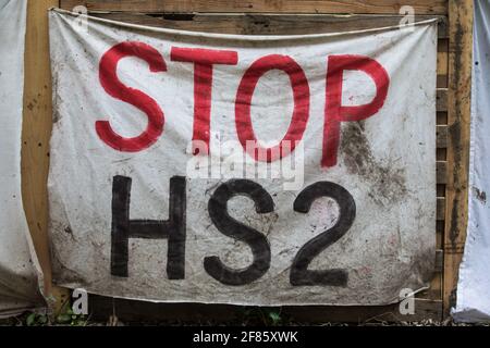 Wendover, Regno Unito. 9 aprile 2021. Un banner Stop HS2 è appeso all'esterno del campo di resistenza attivo di Wendover, occupato da attivisti opposti al collegamento ferroviario ad alta velocità HS2. Il lavoro di abbattimento degli alberi per il progetto si sta svolgendo in diverse località tra il Grande Missenden e Wendover nell'AONB Chilterns, anche di fronte al campo. Credit: Mark Kerrison/Alamy Live News Foto Stock