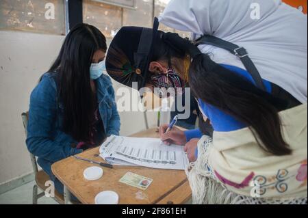 Quito, Ecuador. 11 Apr 2021. Una donna indigena riceve il suo scrutinio dopo aver firmato gli elettori lists.in Cancaghua parrocchia indigena vicino Cayambe nella provincia di Pichincha, le persone provenienti da diverse comunità si trasferiscono nell'unità educativa jose antonio Vallejo per esercitare i loro diritti. Questa domenica viene eletto il nuovo governatore dell’Ecuador. (Foto di Juan Diego Montenegro/SOPA Images/Sipa USA) Credit: Sipa USA/Alamy Live News Foto Stock