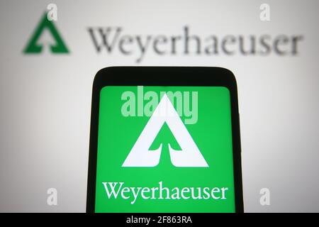 In questa illustrazione fotografica un logo Weyerhaeuser di un'azienda statunitense di investimento immobiliare fiduciario è visto su uno smartphone e uno schermo pc. Foto Stock