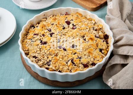 Mela intera e pera sbriciolare con gelato, streusel. Dessert dolce con frutta in umido, composto crumbly croccante servito gelato. Torta di ciottoli di mele in tovaglia. Vista laterale Foto Stock