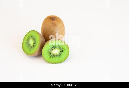 Frutti di kiwi interi e metà isolati su sfondo bianco con spazio di testo Foto Stock