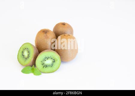 Frutti di kiwi interi e metà isolati su sfondo bianco con spazio di testo Foto Stock